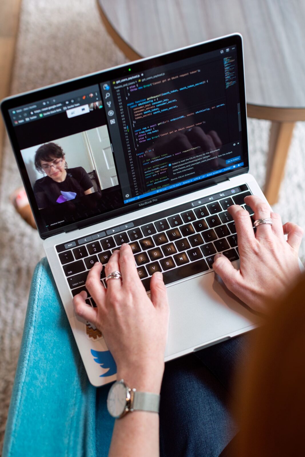 Programmer coding on a laptop during a video call